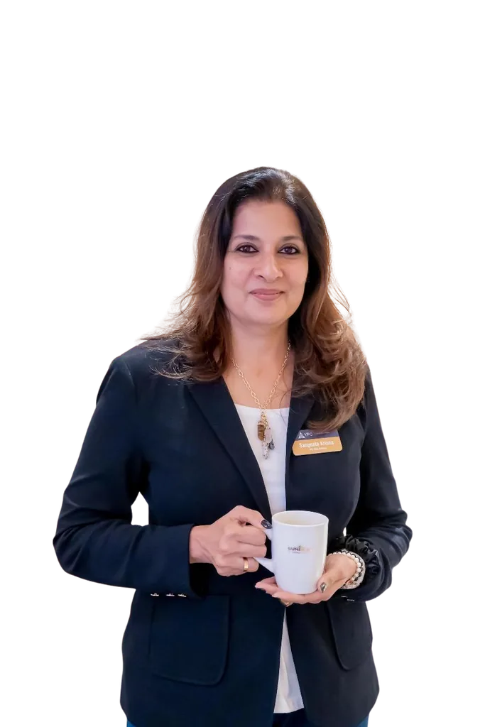 Sangeeta Krisna in a black blazer, holding a Talkwise mug
